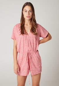 Rood/roze bloemenprint romper met een V-hals, korte mouwen, trekband in de taille en een ontspannen pasvorm. De stof lijkt lichtgewicht en gestructureerd.