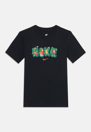 Svart Nike-T-skjorte med fargerik "NIKE"-tekst som viser sportssko, fotballer og leken grafikk over en rød Nike swoosh-logo.