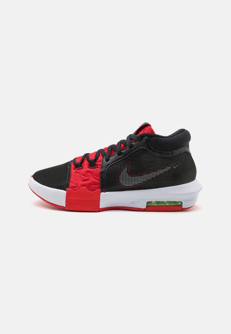 Chaussure de basketball Nike noire et rouge avec semelle blanche et coussin d'air visible au talon, vue de côté sur fond blanc.