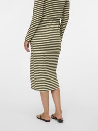 Μακρυμάνικο φόρεμα με ρίγες σε εναλλασσόμενα ελαιώδη πράσινα και λευκά, εφαρμοστό στη μέση, μήκος έως το γόνατο με πλάγιες ανοίγματα, συνδυασμένο με σανδάλια.