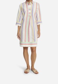 Randig skjortklänning som har pastellfärger på en vit bakgrund, med krage som knäpps, trekvartslånga ärmar och rak skärning.