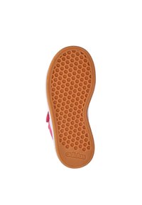 Rode sneaker met een gestructureerde rubberen zool met honingraatpatroon en een oranje basis. De hiel heeft witte en rode accenten.