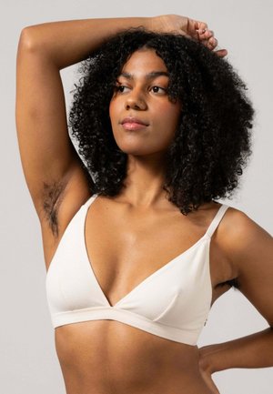 Vitt bomullsbralette med en triangulär form, tunna axelremmar och en mjuk textur. Har en enkel design och en subtil sömdetalj.