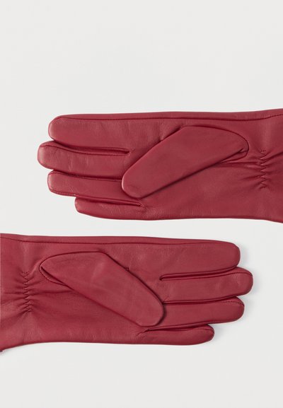 Κόκκινα γάντια από δερμάτινο υλικό με εφαρμοστή σχεδίαση, λεία υφή και λεπτομέρεια με επένδυση στην παλάμη, με ρυτιδιασμένη διακόσμηση κοντά στον καρπό.