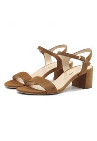 Brown suede block-heel sandals featuring a wide front strap, slim ankle strap with buckle, and a textured surface for added grip.
