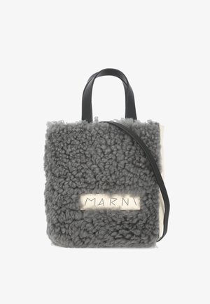 Borsa in shearling grigia con manici in pelle nera, forma rettangolare, e etichetta beige con il nome del marchio "MARNI."