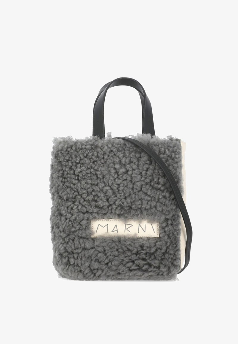 Borsa in shearling grigia con manici in pelle nera, forma rettangolare, e etichetta beige con il nome del marchio "MARNI."