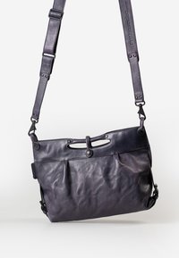 Borsa a spalla in pelle di un viola scuro, con finitura testurizzata, tracolla regolabile, chiusura superiore con manici e due tasche frontali.