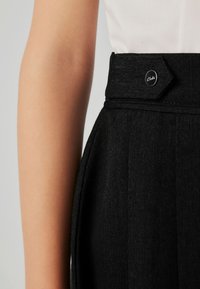 Sorte skræddersyede bukser med en tekstureret finish, der har en unik skrå linning og en metalknap med logo.