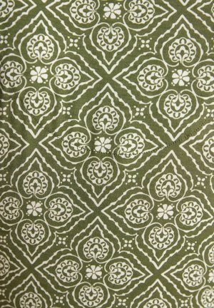Roheline kangas, millel korduvad valged lilled ja südamekujulised sümmeetrilised mustrid, mis moodustavad rombikujulisi mustreid.