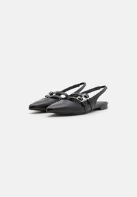Schwarze Leder Slingback-Schuhe mit spitzem Zeh, versehen mit dekorativen Riemen und silberfarbenen Hardware-Akzenten. Niedriger flacher Absatz.