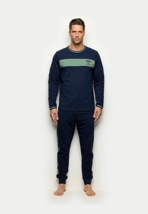 Granatowy zestaw do domowego relaksu z długimi rękawami i dopasowanymi spodniami. Posiada zielony poziomy pasek na wysokości klatki piersiowej z detalem logo.
