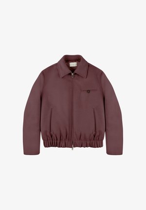 Chaqueta burdeos con cierre frontal, cuello y cintura elástica. Cuenta con un bolsillo en el pecho con botón y una textura suave.