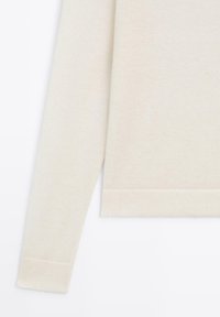 Roomkleurige trui met lange mouwen, gemaakt van zacht gebreide stof, met geribbelde manchetten en zoom, in een losse pasvorm en met minimale textuur.