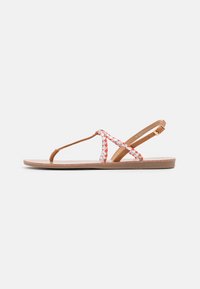 Brown flat sandals with braided red and white straps, a thong design, and an adjustable buckled ankle strap, featuring a textured sole.