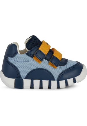 Zapatillas en azul y azul claro con material de cuero y malla, con correas de Velcro amarillas, puntera redondeada y suela segmentada de goma blanca.