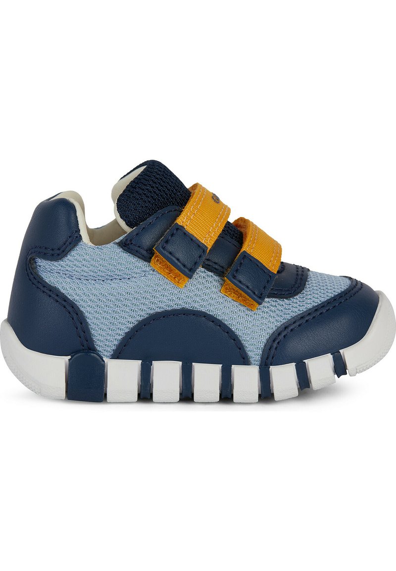 Sneaker blu e azzurro in materiali di pelle e rete, con fascette in velcro gialle, punta arrotondata e suola in gomma bianca segmentata.