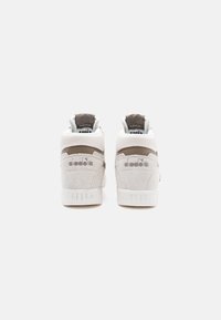 High-top sneakers in white and gray suede, featuring textured panels, logo accents, and padded collars for support and comfort.