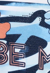 Graphic t-shirt featuring a blue and white wave pattern, orange floral accents, and textured, shiny navy dots on the design.