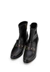 Czarne skórzane botki za kostkę z błyszczącym wykończeniem, z zapięciem na zamek, ozdobami w postaci ćwieków oraz wąskim noskiem.