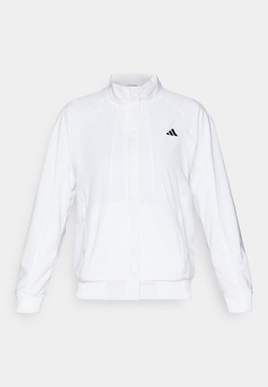Hvid atletisk jakke med opretstående krave, lange ærmer og lynlås fortil. Har et sort logo på den øverste venstre side. Glat tekstur.