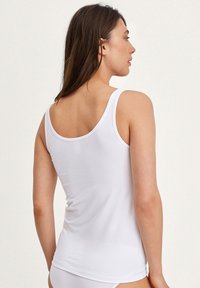 Witte tanktop van gladde stof, met brede schouderbanden en een getailleerd ontwerp, met een lichte stretch bij de taille.