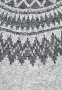 Šedý pletený vzor má geometrický dizajn s striedajúcimi sa bielymi a tmavošedými tvarmi. Mäkká textura s komplexnými detailmi.