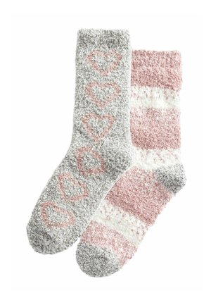 Chaussettes douces en gris avec des motifs de cœurs roses sur l'une, et des rayures roses et blanches sur l'autre. Texture douce et design léger.