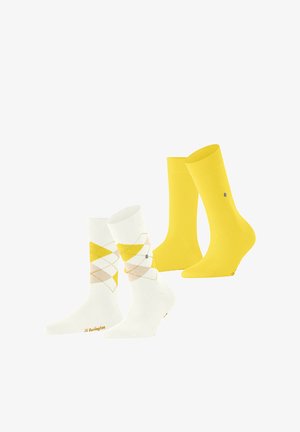 Zwei Paar Socken: ein weißes Paar mit gelbem und beigem Rautenmuster, das andere einfarbig gelb. Beide haben ein kleines rundes Logo.