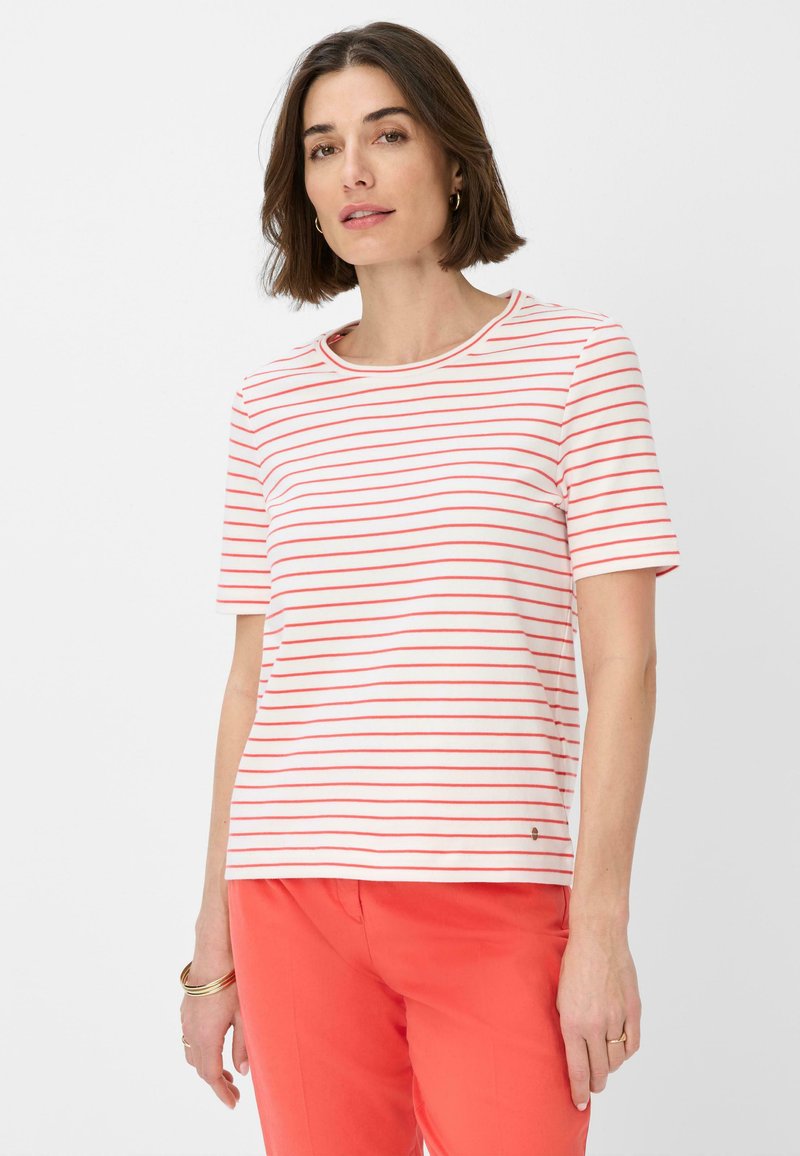 Gestreept T-shirt in het wit met rode horizontale strepen, ronde halslijn en korte mouwen. Gecombineerd met koraalkleurige broek. Zacht jersey materiaal.