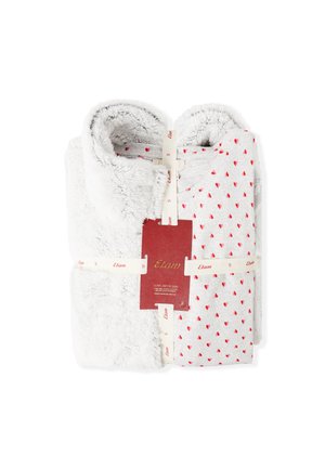 Set accogliente di due coperte: una in morbido tessuto grigio peloso, l'altra grigia con un motivo a cuori rossi, legate con un'etichetta. Texture soffice, design compatto.