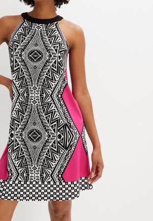 Sleeveless halter dress with black and white geometric patterns, hot pink side panels, and black-and-white checkered hem.