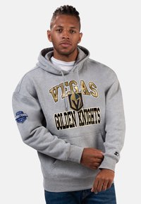 Gray hoodie featuring "VEGAS GOLDEN KNIGHTS" in black and gold. Kangaroo pocket, ribbed cuffs, and NHL Western Conference logo on the sleeve.
