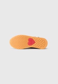 Gummisåle med hexagonalt grip mønster, oransje farge, med en rød hjerte detalj og teksten "LOVE MOSCHINO". Flat form.