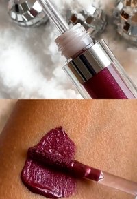 Flytende leppestift i et klart rør med sølvdetaljer. Dyp bærfarge påført huden, viser glanset tekstur og lett shimmer.