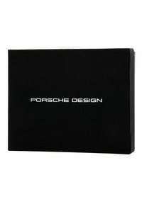 Caja rectangular negra con un acabado mate liso. Presenta el texto blanco "Porsche Design" centrado en la parte frontal. Sin gráficos ni detalles adicionales.