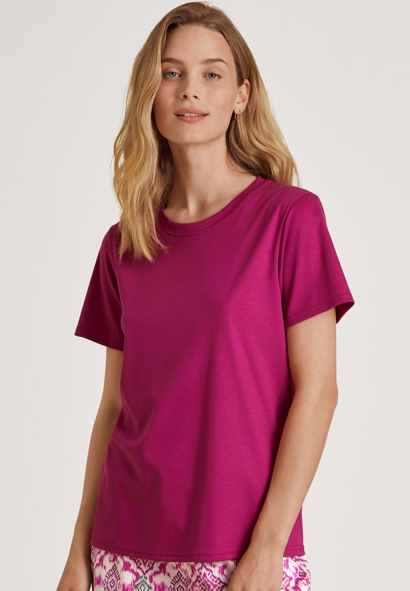 Fuchsia t-shirt met korte mouwen gemaakt van gladde stof en een ronde halslijn. Het heeft een aansluitende pasvorm en minimale naden voor een strakke uitstraling.
