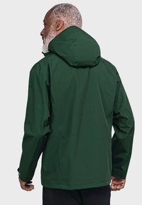 Dunkelgrüne wasserdichte Jacke mit Kapuze, ausgestattet mit einer glatten Textur, verstellbaren Manschetten und minimalistischem Design. Rückansicht gezeigt.