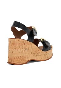 Zwarte leren wedge sandalen met kurken plateau, voorzien van twee ronde zwarte gespen en een open teen design.