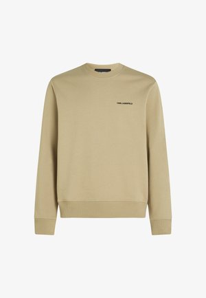 Beige sviiter, millel on ümar kaelus, soonikkoes varrukad ja alläär. Rinnal on väike must logo. Valmistatud pehmest, struktureeritud kangast.