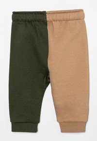 Leggings de algodón cómodos con un diseño dividido en verde oscuro y beige, con una cinturilla elástica y puños acanalados para un ajuste ceñido.