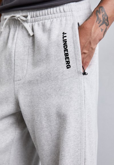 Light grey sweatpants made of soft cotton blend, featuring a drawstring waist, side pockets, and "J.LINDEBERG" logo in black print.