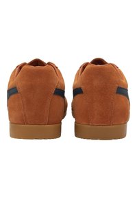 Sneaker in suede marrone con accenti blu navy, design con retro arrotondato e suola in gomma. Texture liscia e dettagli di cucitura puliti.