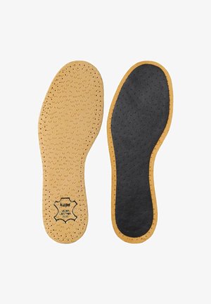 Deux semelles de chaussure perforées, l'une beige avec une étiquette en cuir, l'autre noire avec des bords beiges, toutes deux plates et adaptées à la forme des pieds.
