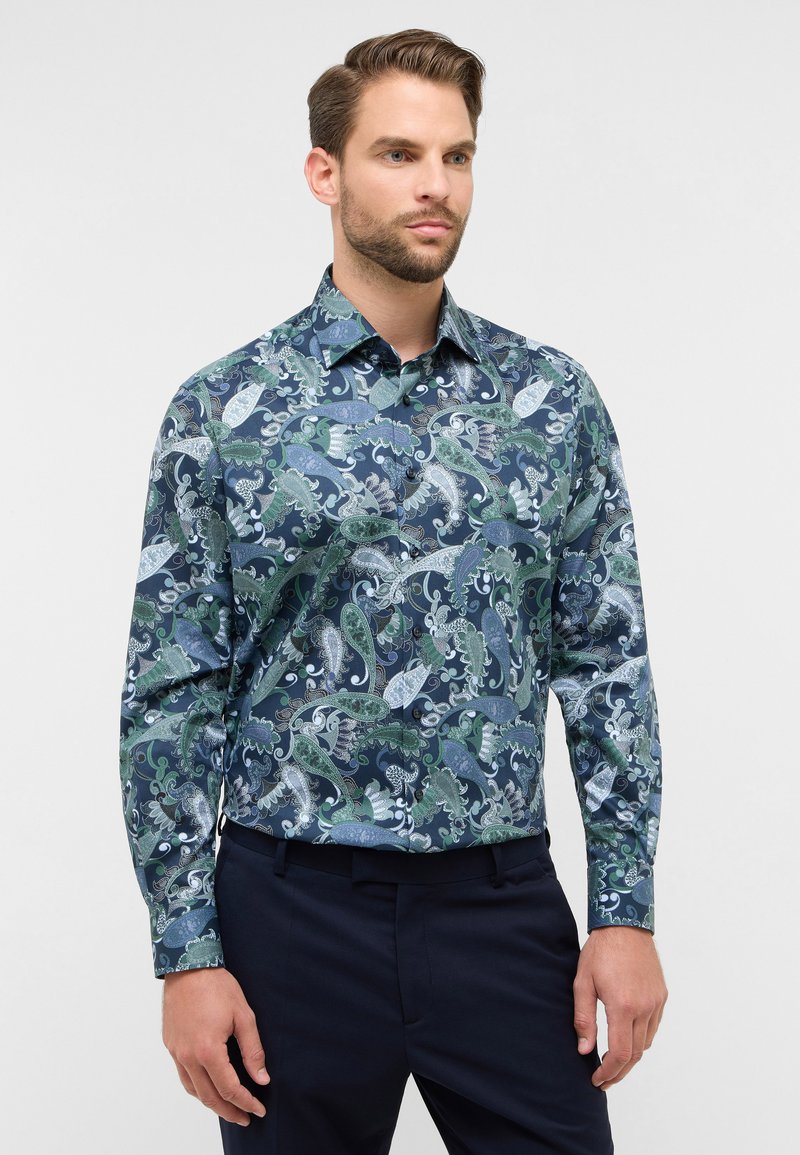 Heren overhemd met lange mouwen gemaakt van gemêleerde stof met groene, blauwe en witte paisley ontwerpen op een donkerblauwe achtergrond.