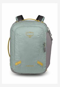 Zaino in tessuto verde a quadretti con accenti grigi, accessori gialli, tasca frontale con zip, spallacci imbottiti e maniglia superiore.