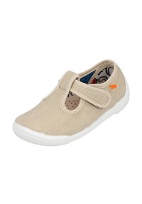 Zapato de lona color beige con una correa de velcro, suela de goma blanca, punta redondeada y acentos perforados. Forro interior de diseño colorido visible.
