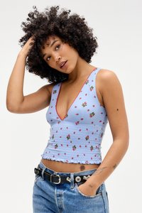 Svijetloplavi cvjetni crop top s naboranim uzorkom, dizajn s V-izrezom, crvenim obrubom i prilagođenim oblikom, uparen s traper šortsevima viskog struka i crnim remenom.