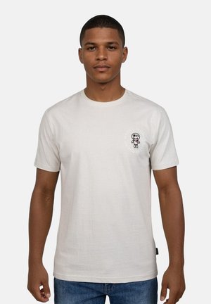 Lichtbeige katoenen t-shirt met een ronde hals, korte mouwen en een cartoonafbeelding op de linker borst.