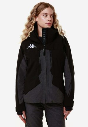 Giacca nera e grigia con cappuccio, tasche frontali con zip, logo Kappa, tessuto testurizzato, vestibilità over e polsini regolabili.